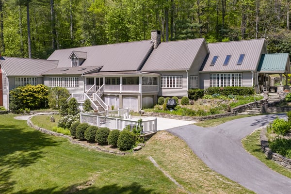 Spacious home surrounded by lush greenery, featuring ample outdoor space and unique architectural design.