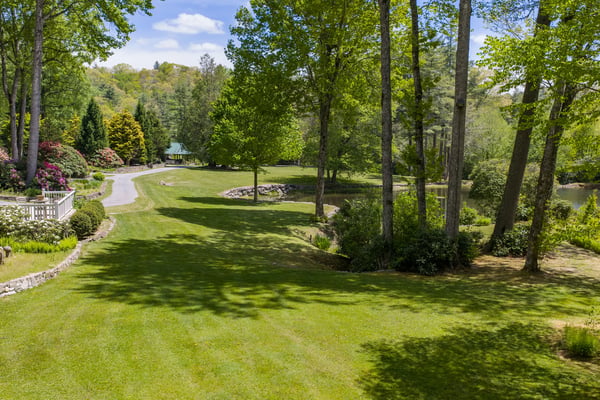 Spacious grounds feature lush greenery and a tranquil pond, perfect for outdoor gatherings and relaxation.