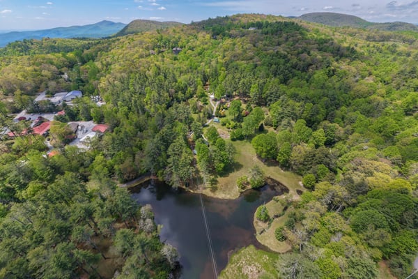 Discover a picturesque property featuring lush landscapes, a peaceful pond, and stunning mountain views.