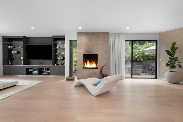 This bright living area features a contemporary fireplace and seamless indoor-outdoor flow to the patio.