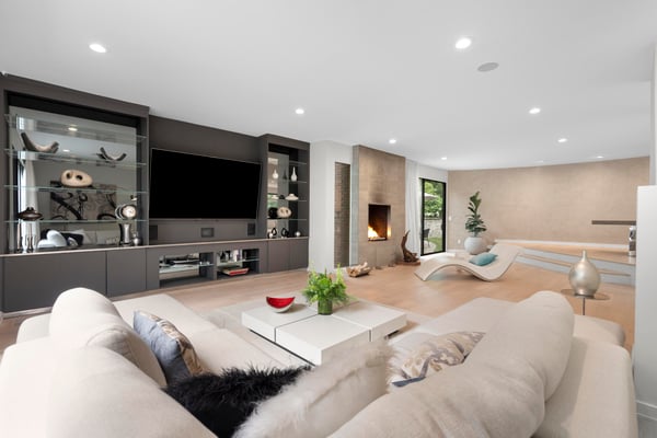 Spacious living area featuring a contemporary fireplace, sleek storage, and large windows for abundant natural light.