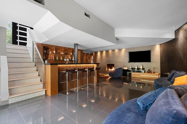 Spacious open-concept living area with a modern bar, sleek finishes, and inviting fireplace for cozy gatherings.