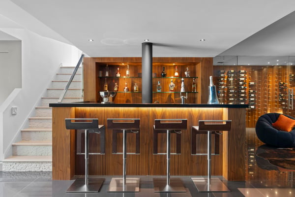 Modern basement bar featuring sleek seating and a sophisticated wine display, perfect for entertaining guests.