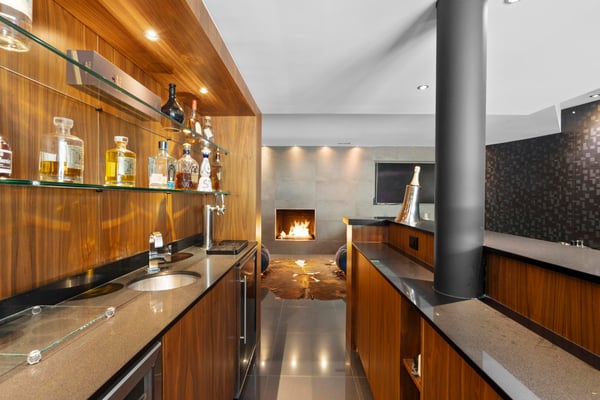 This contemporary kitchen features sleek wooden cabinetry, a cozy fireplace, and a modern ambiance perfect for entertaining.