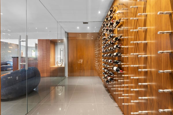 This modern entryway features a stunning wine display wall and sleek glass accents for a contemporary feel.