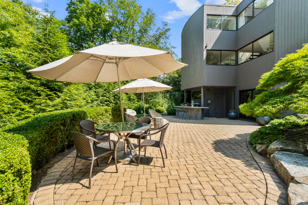 Discover a secluded outdoor space with a patio, perfect for relaxation and entertaining amidst lush greenery.