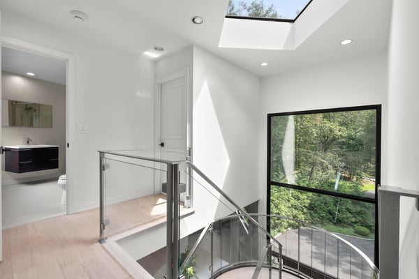 Bright and inviting foyer features modern design elements and abundant natural light, overlooking lush greenery.