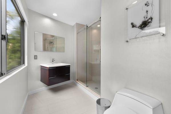 Modern bathroom featuring sleek fixtures, ample natural light, and a spacious walk-in shower for ultimate comfort.