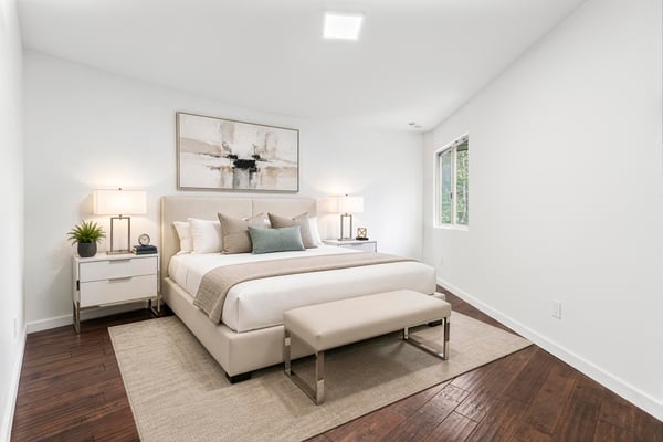 Bright and inviting bedroom featuring modern decor, ample natural light, and a cozy seating area.