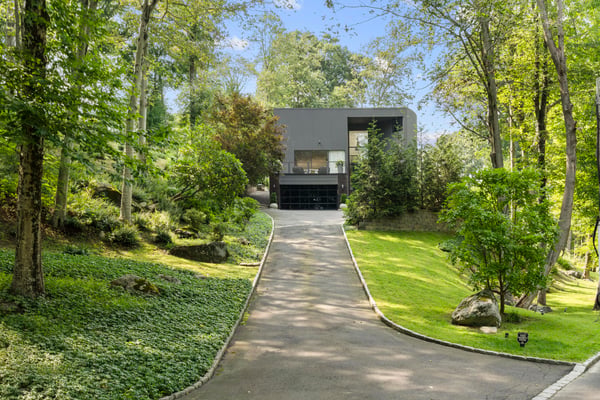 Modern home nestled within lush greenery, featuring a spacious driveway and tranquility just minutes from the city.
