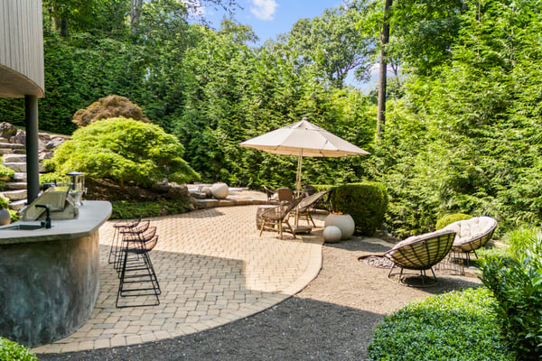 Discover your private outdoor oasis, featuring tiered landscaping, lounge areas, and a shaded retreat.