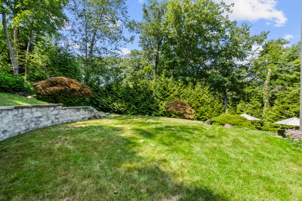 Spacious, landscaped backyard offers a perfect retreat surrounded by lush greenery and mature trees.