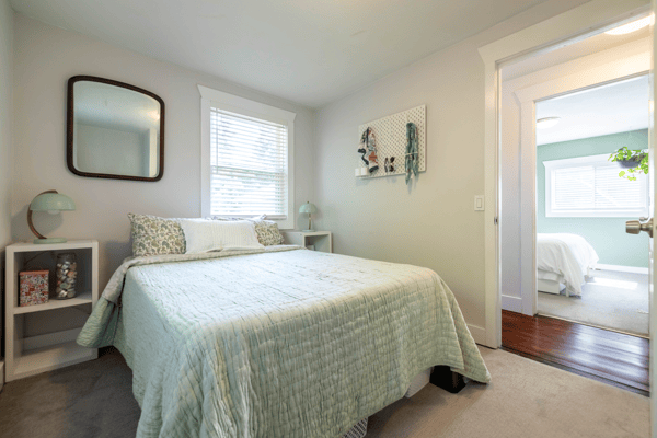 Bright bedroom featuring a cozy layout, large windows, and modern decor throughout for comfortable living.