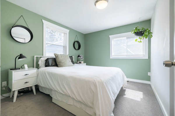 Bright and inviting bedroom featuring fresh paint, natural light, and modern touches for comfortable living.