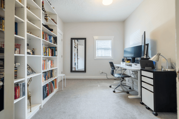 Bright and functional office space featuring built-in bookshelves and ample room for workspace or study.