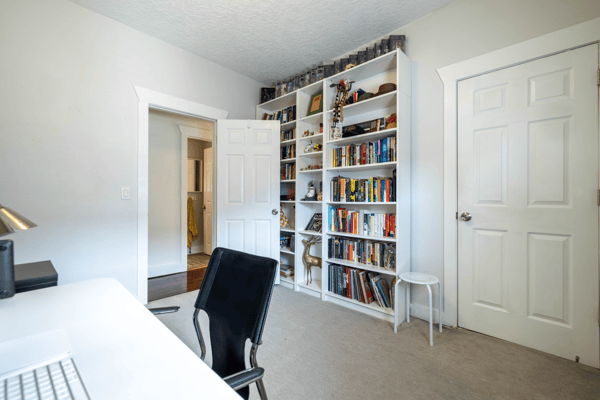 Bright and inviting room featuring a spacious bookshelf and a comfortable workspace, perfect for productivity.