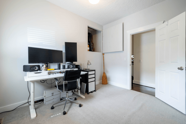 Bright home office space featuring dual monitors, ample storage, and a practical layout for productivity.