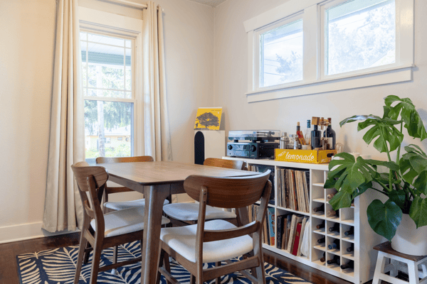 Bright dining area featuring a wooden table, modern decor, and ample natural light, perfect for gatherings.