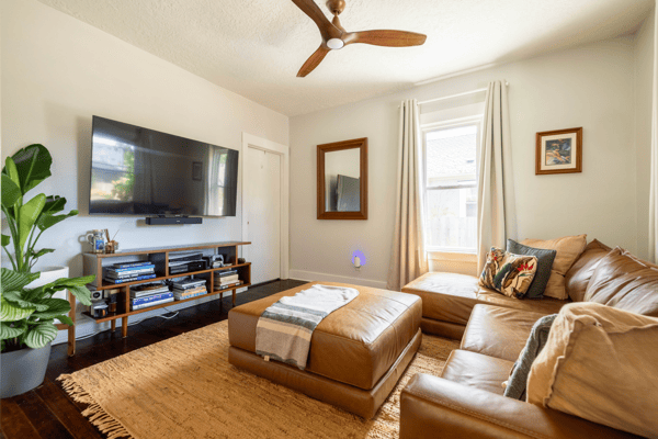 Bright living room featuring a large TV, modern furniture, and natural light enhancing the inviting atmosphere.