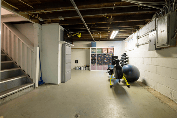 Spacious unfinished basement featuring ample room for storage and home fitness equipment, ideal for customization.