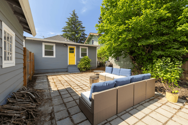 Bright outdoor space featuring a cozy seating area, surrounded by lush greenery and a welcoming atmosphere.