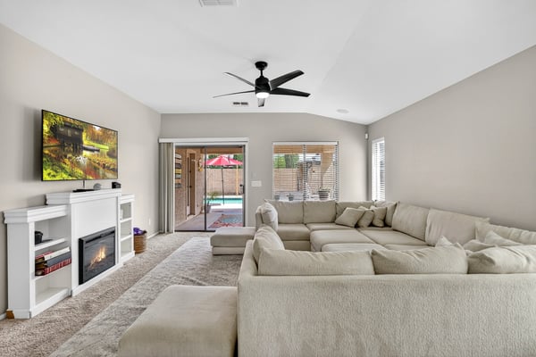 Light-filled living room with fireplace and direct access to the backyard pool area. Open design creates a welcoming space for relaxing or entertaining in this Casa Grande home.