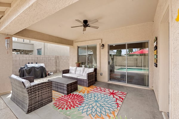 Outdoor living space with covered patio and seating area, perfect for relaxing or hosting. Easy access to the pool enhances the Casa Grande lifestyle.