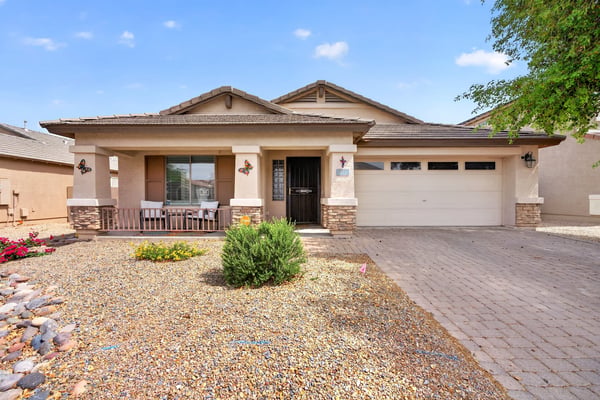 Attractive exterior with covered porch, desert landscaping, and attached garage. Clean curb appeal defines this Casa Grande property.