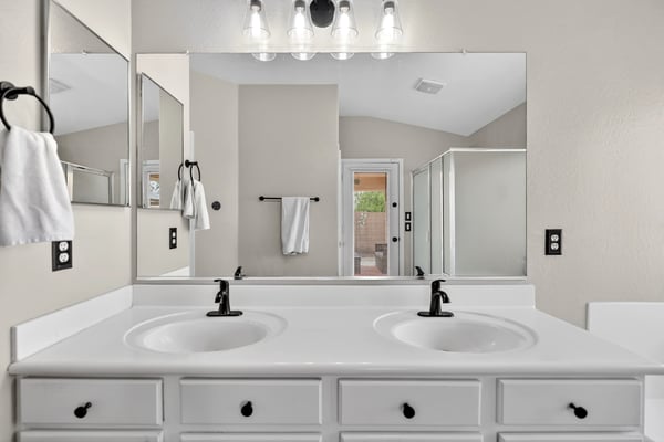 Spacious primary bathroom with dual vanities and modern fixtures. Functional layout enhances everyday convenience in Casa Grande.