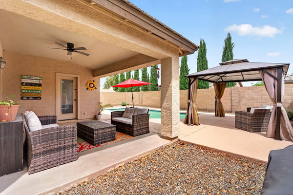 Covered patio with seating and views of the pool and pergola area. Designed for entertaining and enjoying Arizona-style outdoor living in Casa Grande.