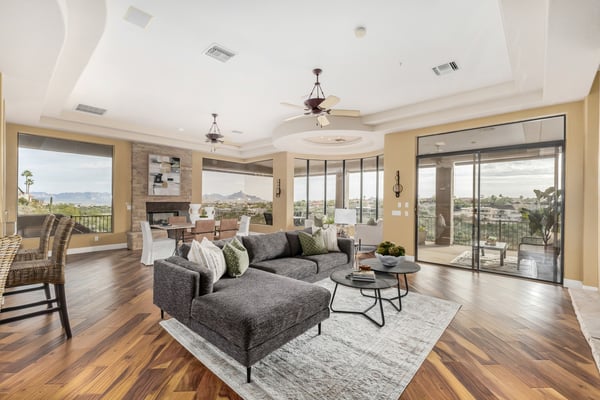 Bright and spacious living area designed to maximize natural light and showcase sweeping mountain vistas. Large windows, warm wood flooring, and an open layout create an inviting atmosphere for entertaining and everyday living.