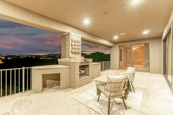 Elegant outdoor retreat showcasing a built-in fireplace, covered seating area, and breathtaking evening skies. This Fountain Hills patio delivers warmth, ambiance, and unforgettable desert views.