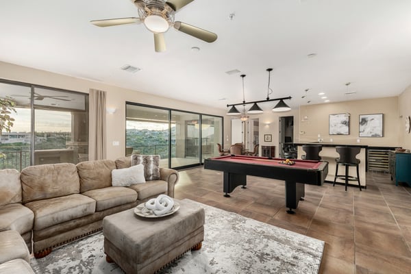 Spacious game and entertainment room featuring a pool table, built-in wet bar, and large sliding glass doors opening to the covered patio. This versatile lower-level retreat combines indoor comfort with stunning Fountain Hills scenery.