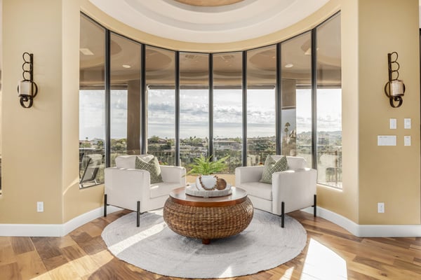 Stunning sitting area framed by floor-to-ceiling windows that bring the surrounding desert landscape indoors. The perfect space to relax while taking in the home's elevated views.