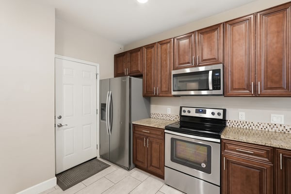 Beautiful kitchen showcasing stainless steel appliances, granite work surfaces, and rich cabinetry. Designed for efficiency and style, this space serves as the heart of the home.
