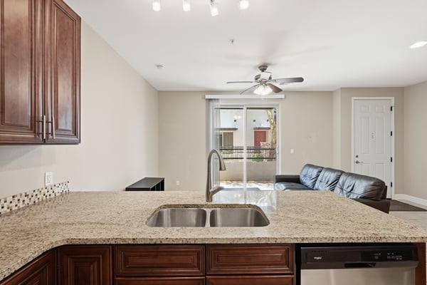 Large granite breakfast bar with integrated sink and plenty of workspace. The open design provides additional seating while connecting the kitchen and living areas.