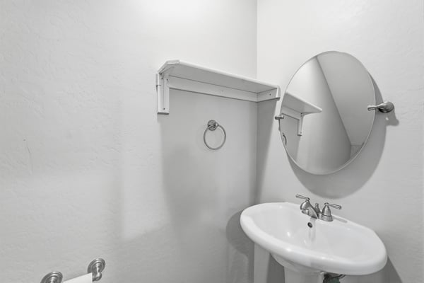 Convenient guest powder room featuring neutral finishes and easy accessibility. A valuable feature that adds comfort and functionality for homeowners and visitors alike.
