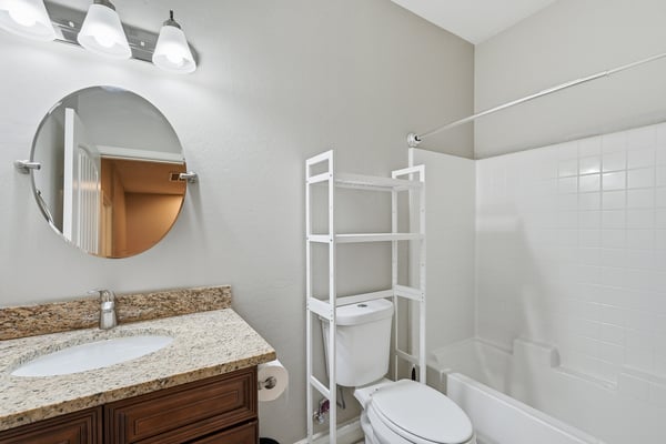Full bathroom featuring granite countertops, updated cabinetry, and a tub/shower combination. A clean, functional space that complements the home's move-in-ready appeal.