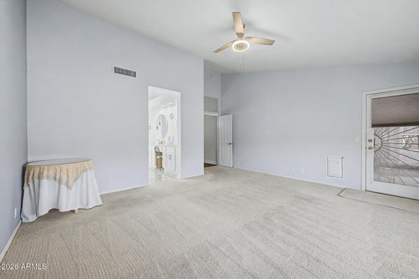 The spacious owner's suite features high ceilings, direct bathroom access, and room for additional seating or furnishings. Natural light enhances the comfortable and inviting atmosphere.