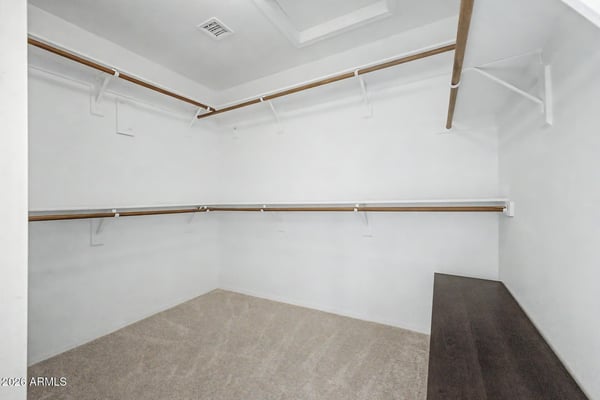 This large walk-in closet offers exceptional organization with multiple hanging rods, shelving areas, and dedicated storage space. A practical feature that enhances everyday convenience and functionality.