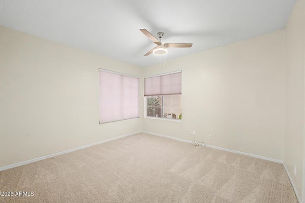 Natural light, neutral finishes, and plush carpeting create a warm and inviting atmosphere in this secondary bedroom. The spacious layout offers flexibility for guests, work-from-home needs, or additional living space.