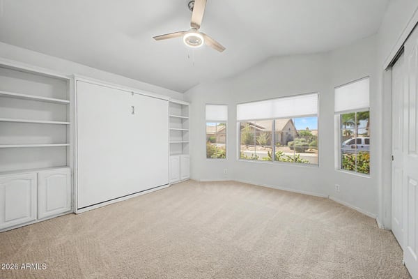 Custom shelving and a built-in Murphy bed make this room highly functional and adaptable. Large windows brighten the space while offering flexibility for overnight guests, hobbies, or remote work.