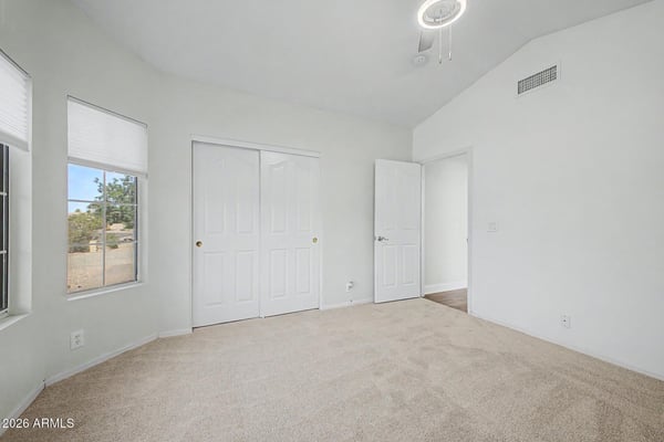 Offering generous dimensions, soft carpeting, and a large closet, this bedroom provides a comfortable and flexible space for family members or guests within this attractive Peoria home.