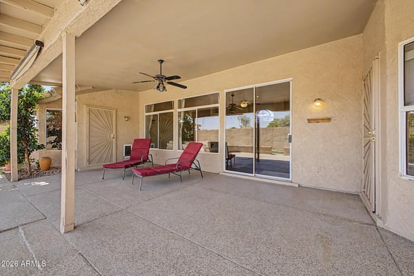 This covered patio offers abundant room for outdoor dining, entertaining, and relaxation. Ceiling fans and seamless access to the home's interior create a comfortable extension of the living space.