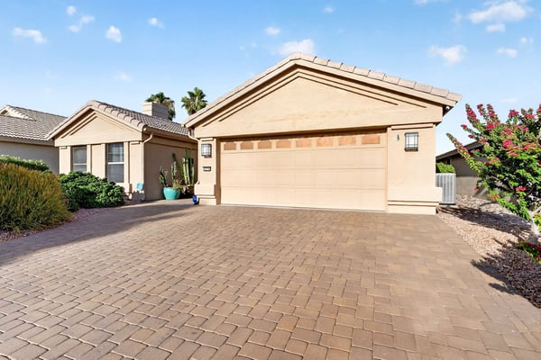 A large paver driveway provides additional parking space while leading to the attached two-car garage. The upgraded hardscape adds both functionality and visual appeal to the property's exterior.