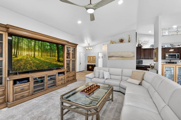 his spacious living room offers plenty of room for entertaining, relaxing, and enjoying everyday life. Large windows, plantation shutters, and soaring ceilings enhance the bright and comfortable atmosphere.