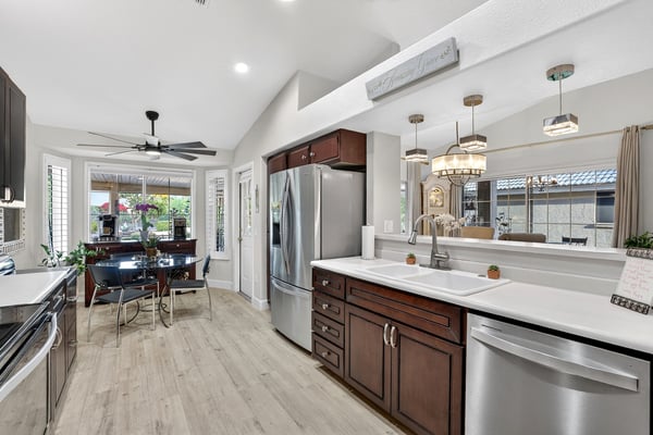 This updated kitchen blends style and functionality with stainless steel appliances, extensive cabinetry, and a casual dining area. Backyard views and natural light enhance the welcoming atmosphere.