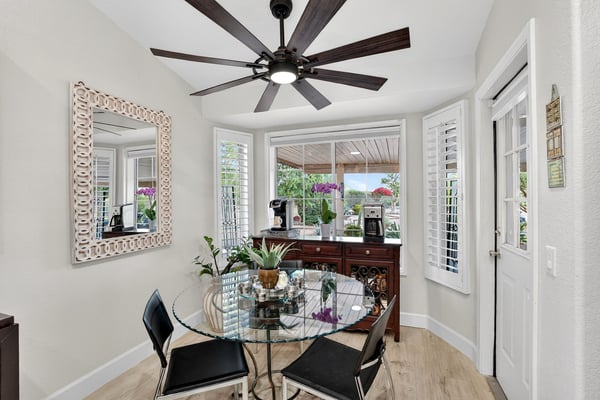 Surrounded by windows and overlooking the backyard, this breakfast nook creates the perfect setting for daily meals. Plantation shutters and updated flooring add style and practicality.