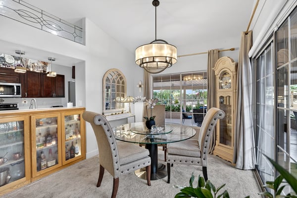 Enjoy elegant dining with views of the covered patio and landscaped outdoor space. High ceilings and designer lighting create an inviting atmosphere for entertaining.