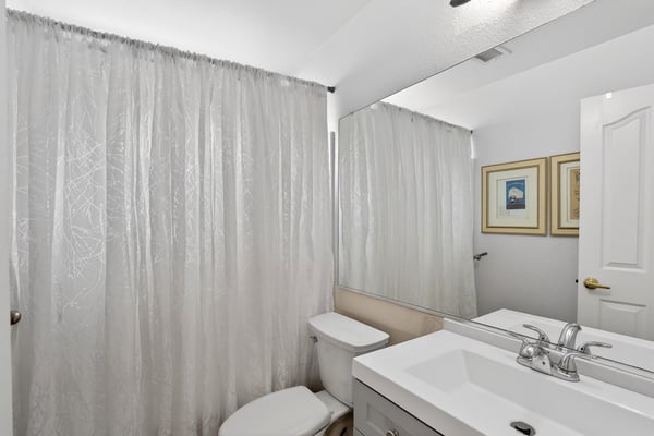 This well-maintained guest bathroom features modern finishes, a spacious vanity, and a convenient tub-shower combination. A bright and functional space for everyday use.
